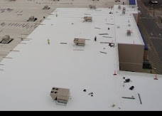 Elevated view of a large light-colored roof and rooftop equipment.