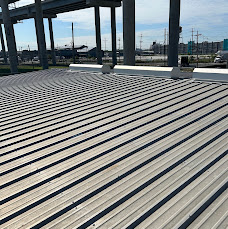 Corrugated metal decking beneath a steel frame during construction.