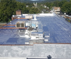 Reflective roof surface surrounding rooftop equipment and penetrations.
