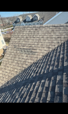 Close view of shingles across intersecting residential roof slopes.