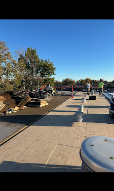 Crew preparing a flat roof around roof penetrations.